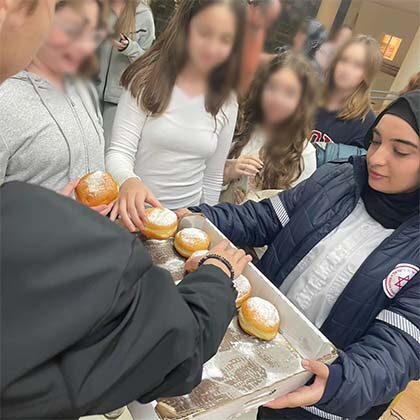 MDA shares Chanukah donuts with evacuees.